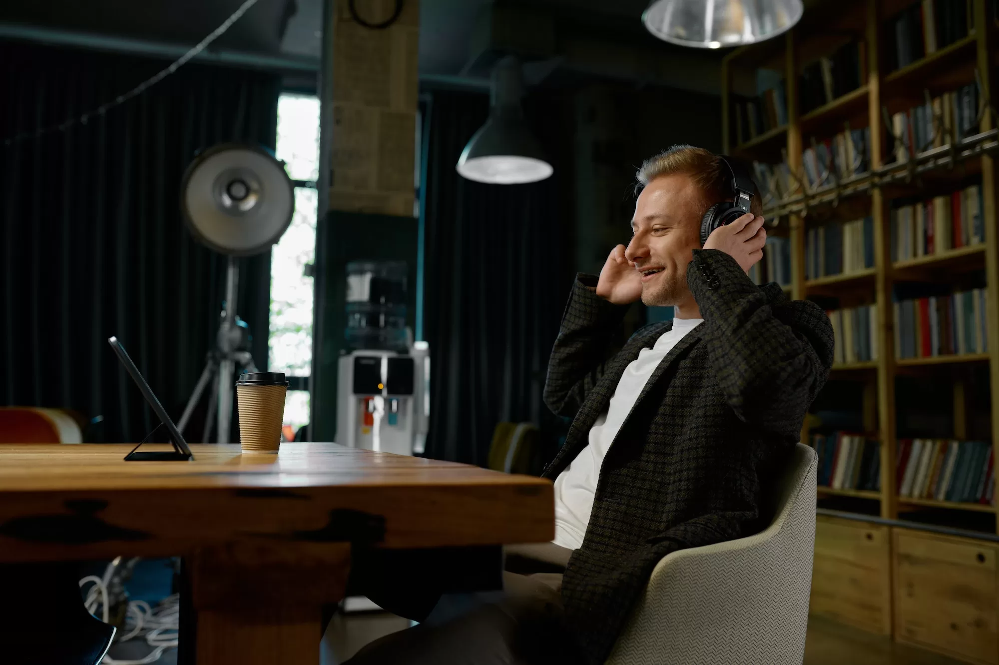 Relaxed office worker in headphones having break listening to music