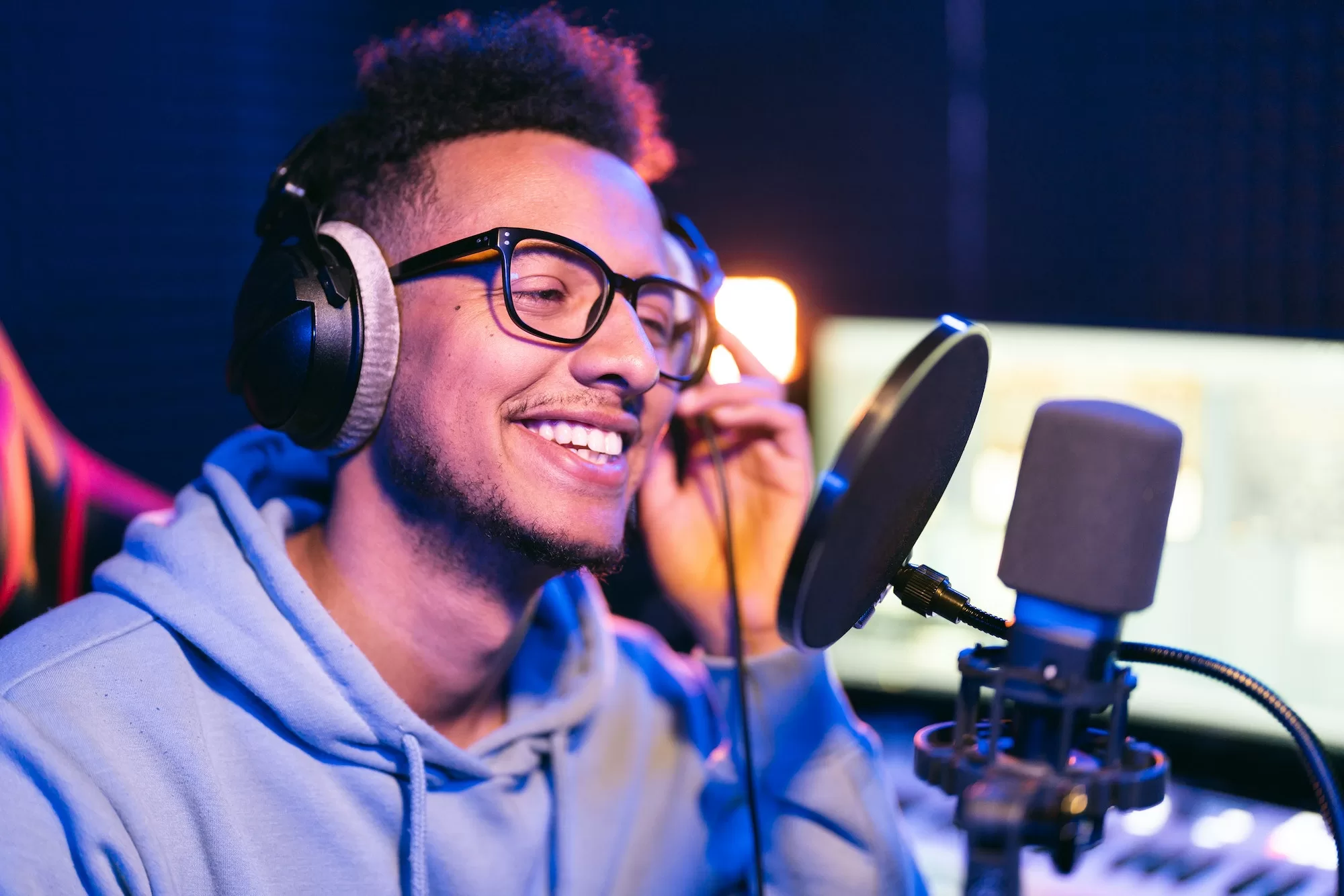 Young male singer in recording studio performing in neon lights